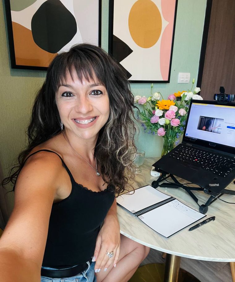 Marchela at her desk with fresh flowers